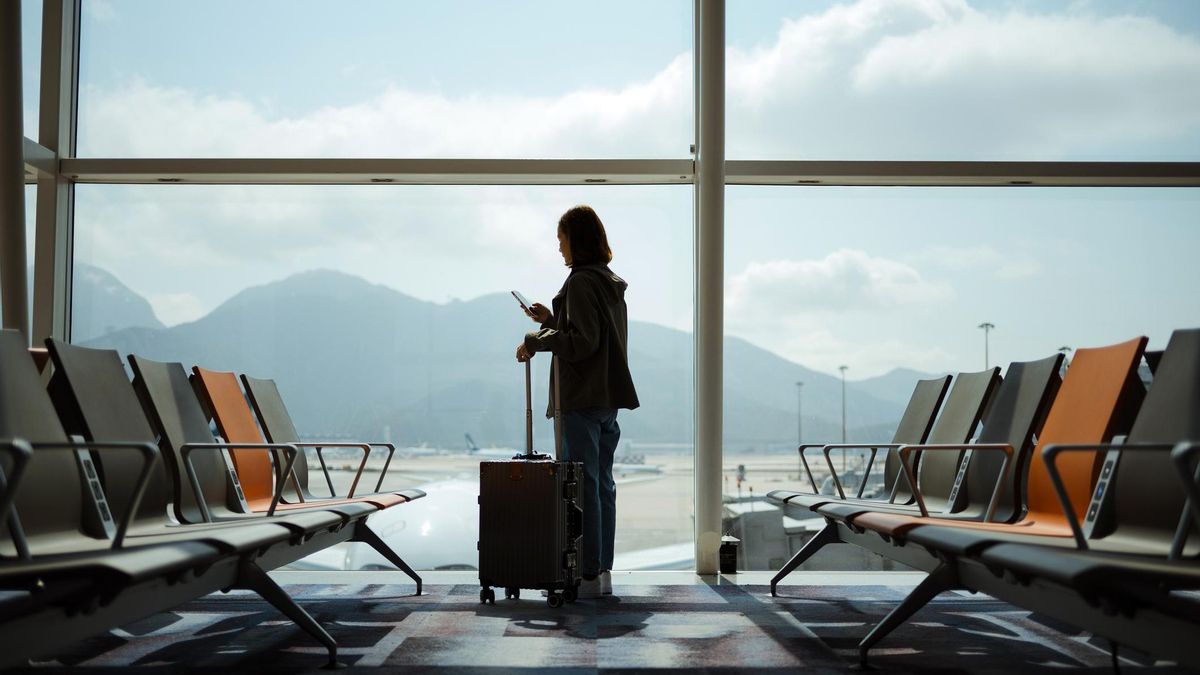 Una viajera utiliza su teléfono en el aeropuerto.