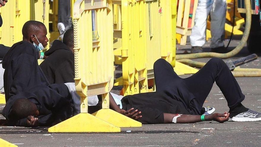 Hombres en el suelo del muelle de Arguineguín tras haber llegado en patera a Canarias EFE/ Elvira Urquijo A.