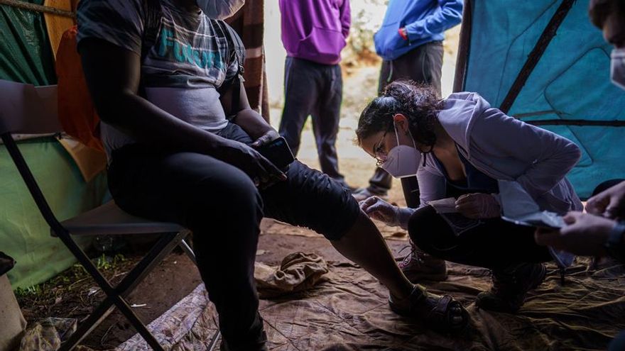 Rocío, enfermera voluntaria, atendiendo a uno de los inmigrantes del campamento Las Raíces