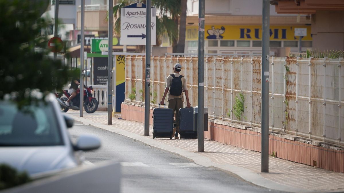 Un trabajador abandona la zona con sus maletas tras el desahucio.