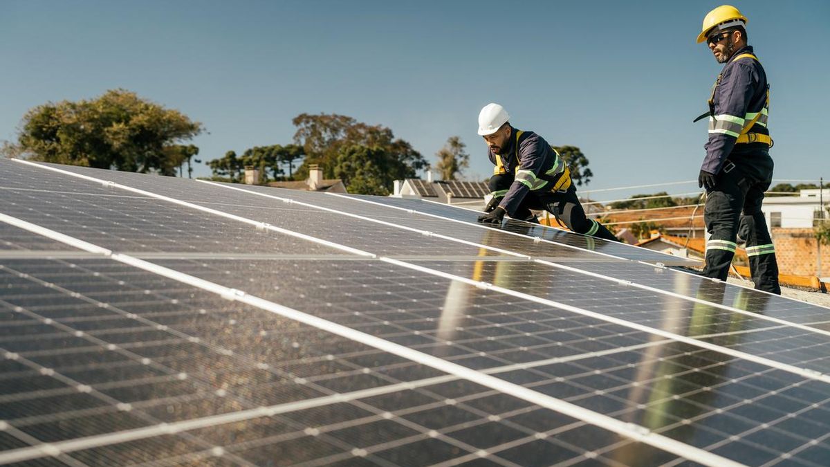 Dos trabajadores colocando paneles de energía solar
