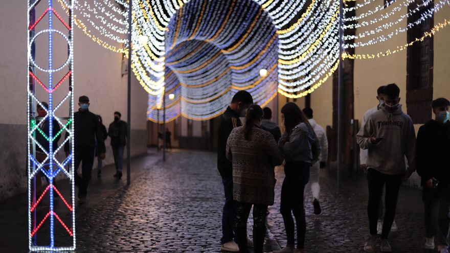 Varias personas pasean por las calles alumbradas de La Laguna