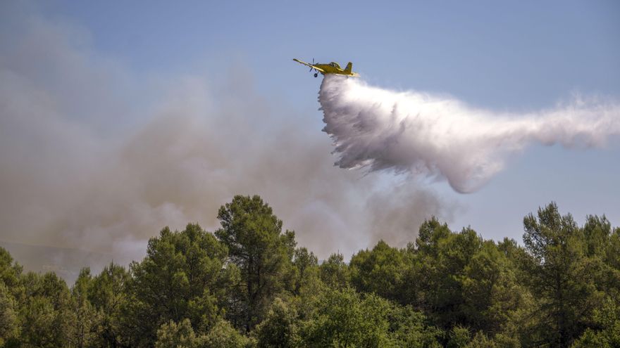 Un avión de los Bomberos actúa en la zona afectada por en incendio en el Pla de Manlleu,  en Aiguamúrcia (Tarragona).EFE/ Àlex López