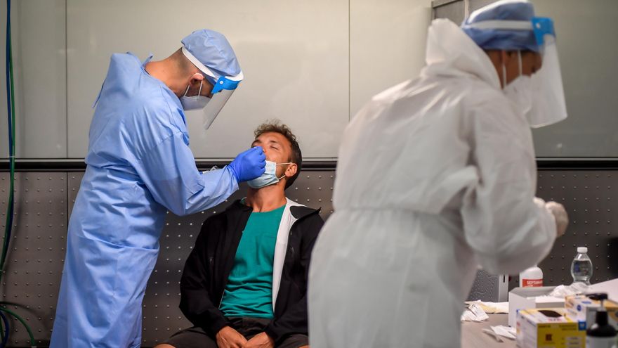 Un sanitario realiza un test de coronavirus a un pasajero en el Aeropuerto de Milán-Malpensa