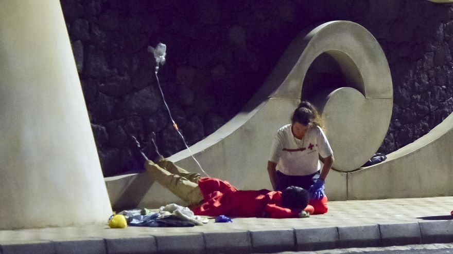 Una voluntaria de Cruz Roja asiste a uno de los supervivientes del cayuco rescatado en El Hierro con 173 personas a bordo
