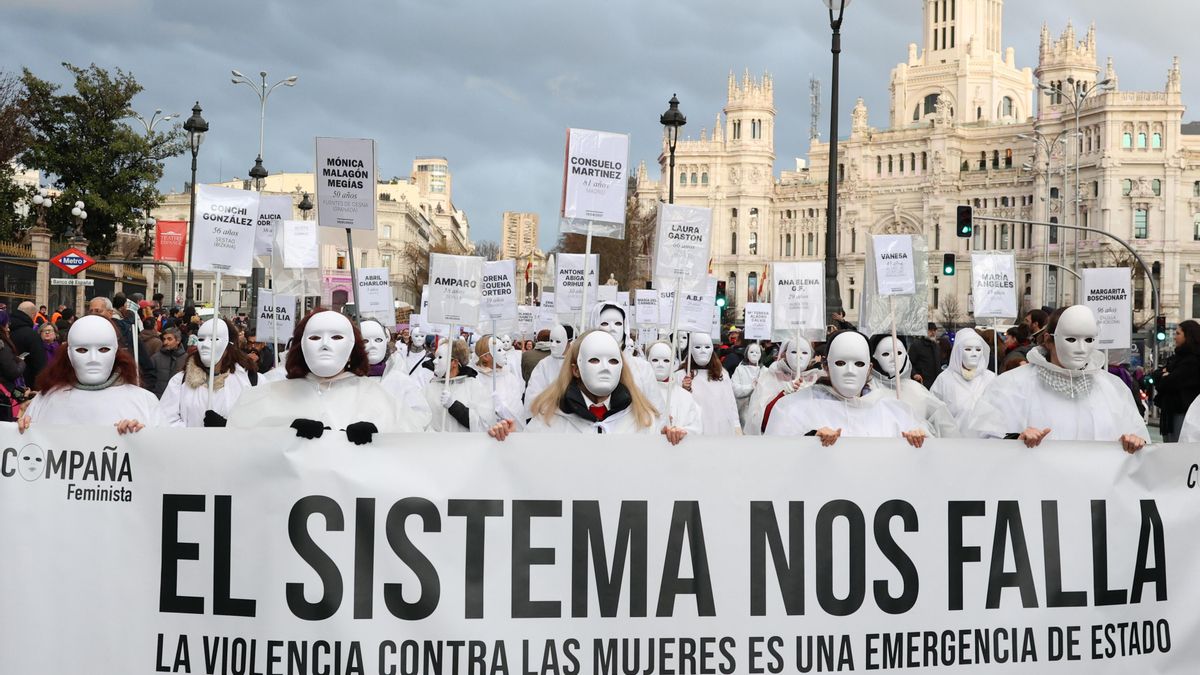 Las mujeres de la 'Compaña Feminista' recuerda, vestidas de blanco y con máscaras, a las fallecidas a causa de la violencia machista.