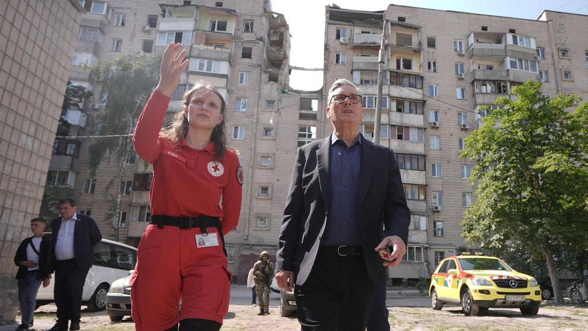 El primer ministro británico, Keir Starmer, durante su última visita oficial a Kiev, Ucrania, este jueves con una responsable de emergencias ante un edificio bombardeado por Rusia.