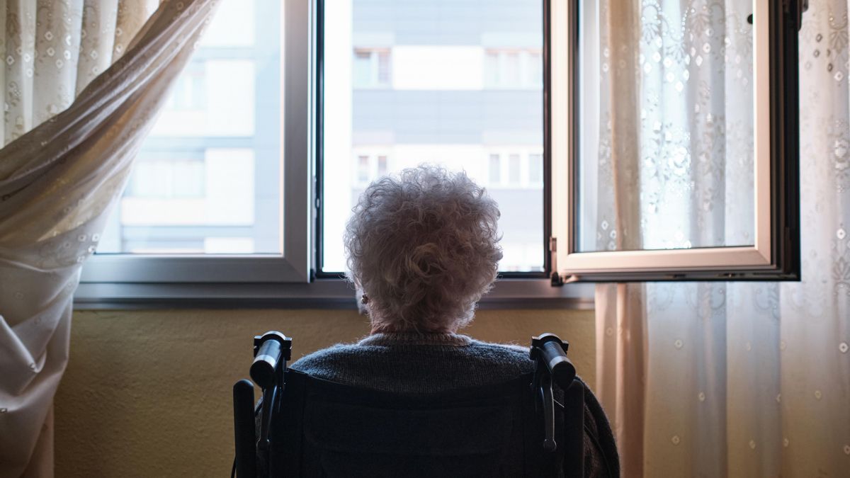 Una anciana mirando por la ventana.