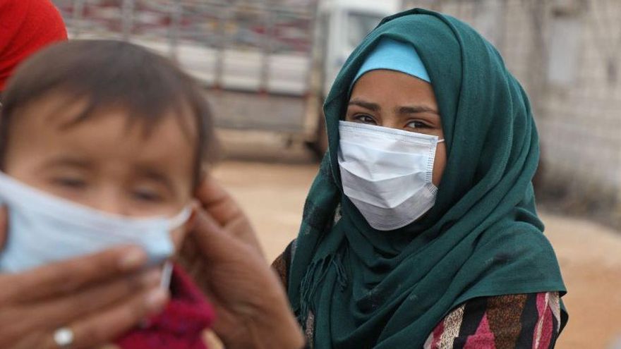Una mujer y un niño en un campamento de refugiados durante la pandemia