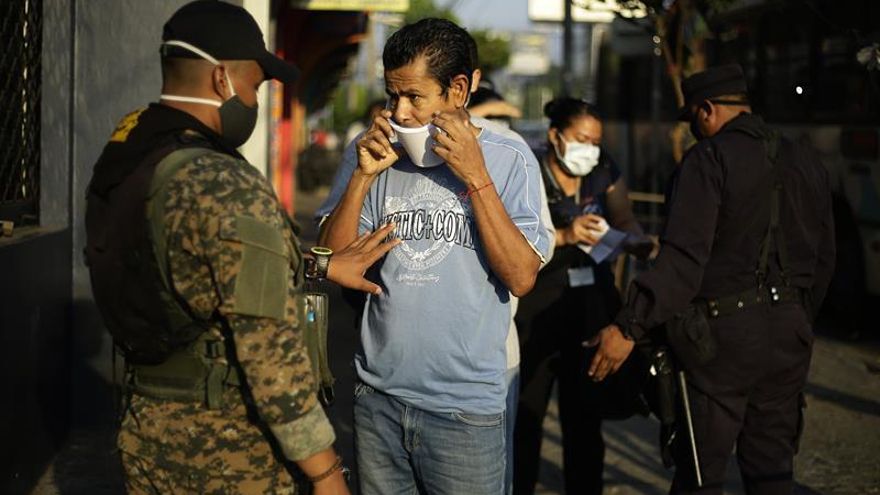 Agentes policiales mantienen un punto de control para personas que deban desplazarse por el centro de San Salvador (El Salvador).