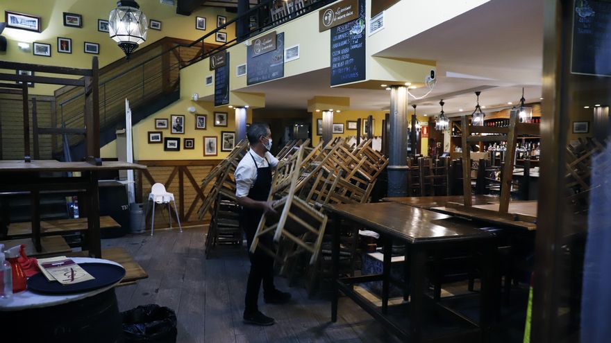 Un camarero recoge en el interior de un bar.