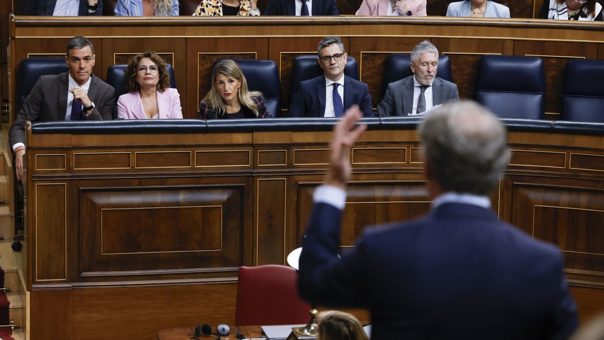 El presidente del Gobierno, Pedro Sánchez, y varios miembros del gobierno escuchan la intervención del líder del PP, Alberto Núñez Feijóo (de espaldas), en la sesión de control al Ejecutivo en el Congreso, en Madrid. EFE/  JJ Guillen