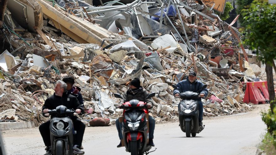 Hombres en motocicleta junto a los escombros de un edificio destruido en la zona de Al Chiyah, un suburbio al sur de Beirut.