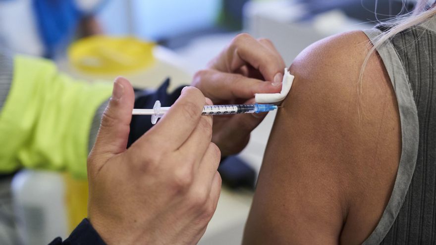 Un sanitario vacuna a una mujer