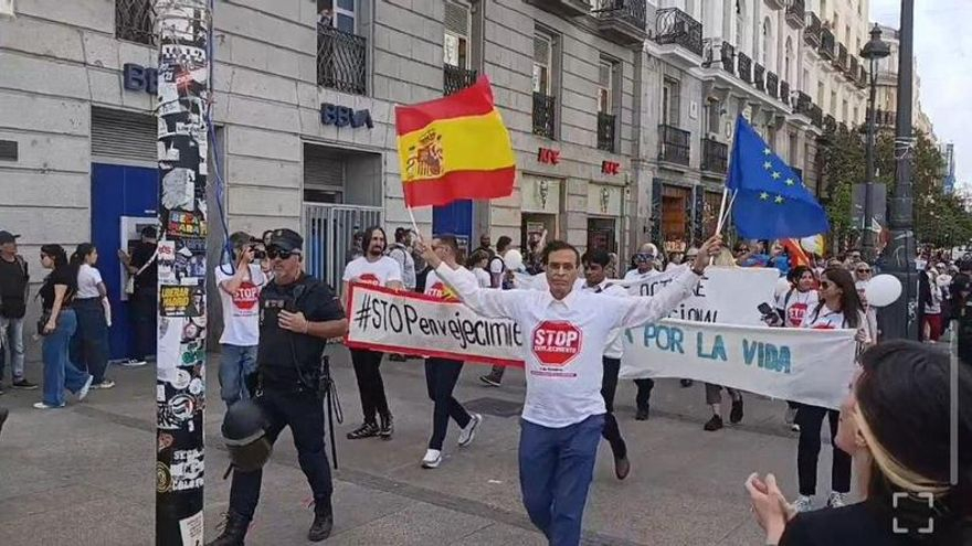 Un grupo de personas atraviesa Sol con banderas de España
