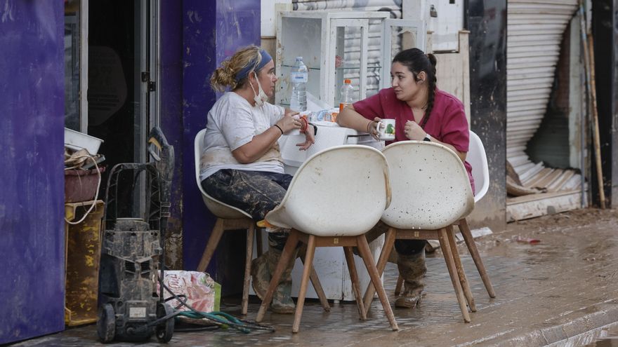 Dos vecinas del municipio valenciano de Sedaví descansan este martes, tras el paso de la Dana.
