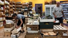 Lourdes López y Emilio Lázaro, dos socios de la tienda ecológica Biolíbere, en Getafe, acomodan el local.