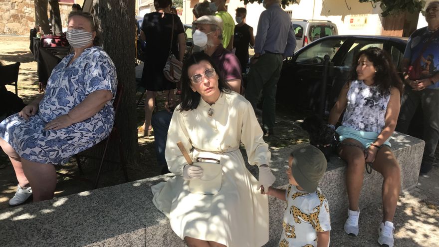 Un niño se acerca a saludar a Miss Beige en la plaza central de Buitrago