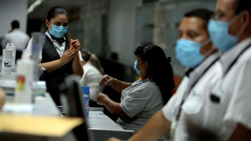 - Empleados de líneas aéreas que funcionan en las instalaciones del Aeropuerto Internacional Toncontín se protegen con mascarillas hoy miércoles en Tegucigalpa.