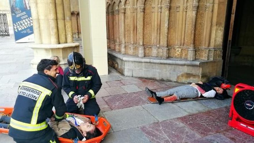 Tres personas -falsamente- heridas en el momento de ser atendidas por los cuerpos de seguridad en la puerta principal de la Catedral de León. / C.J.D.