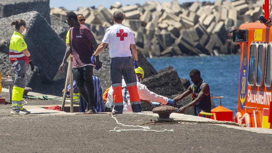 Archivo - Varios migrantes desembarcan de un cayuco.