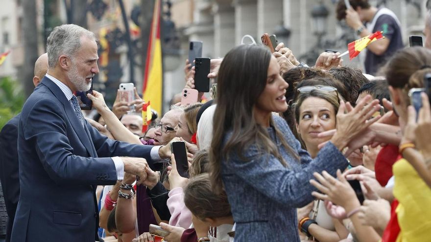 El rey Felipe VI y la reina Letizia saludan a la multitud que espera su llegada ante el Ayuntamiento de Ceuta, este martes.