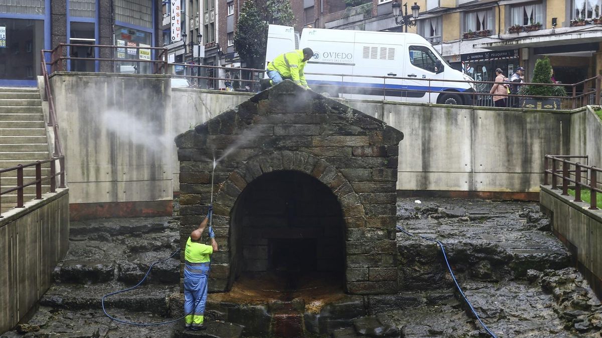 Dos operarios realizan tareas de limpieza en la fuente de La Foncalada.