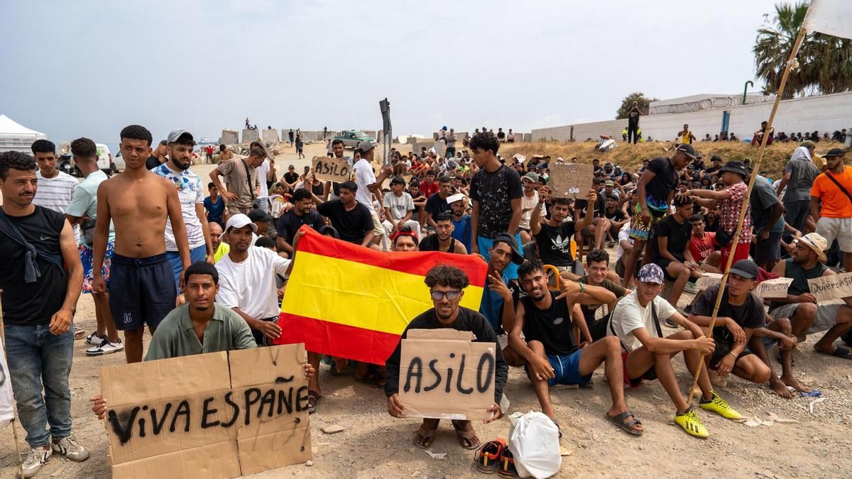 Un grupo de migrantes concentrados para solicitar asilo este domingo en la playa del Trampolín de Ceuta