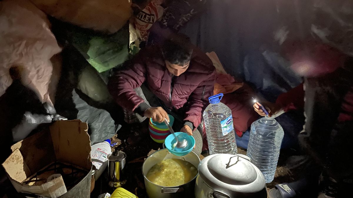 Uno de los migrantes que pernoctaba en el exterior de Las Raíces repartiendo la comida que llevaban los vecinos y vecinas de la isla