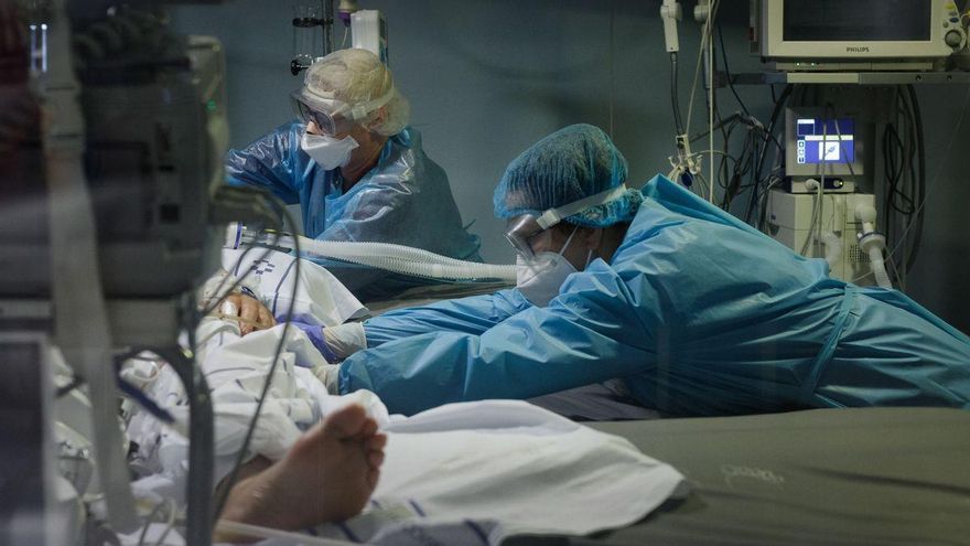 Personal sanitario atiende a un paciente en UCI.