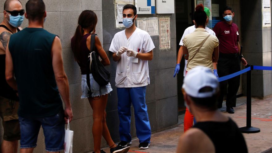 Ciudadanos del barrio del Besós de Barcelona, guardan cola frente a uno de los dispositivos instalados en este barrio durante el cribado voluntario y masivo de COVID-19, este miércoles. EFE/ Quique Garcia