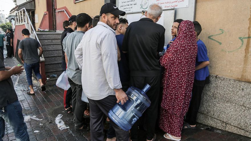 Los residentes de la ciudad de Gaza cargan botes de agua.