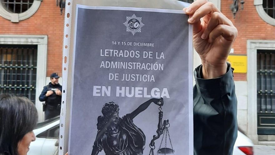 Una manifestante sujeta un cartel ante el Ministerio de Justicia en el que pide aumento salarial para los Letrados de la Administración de Justicia.