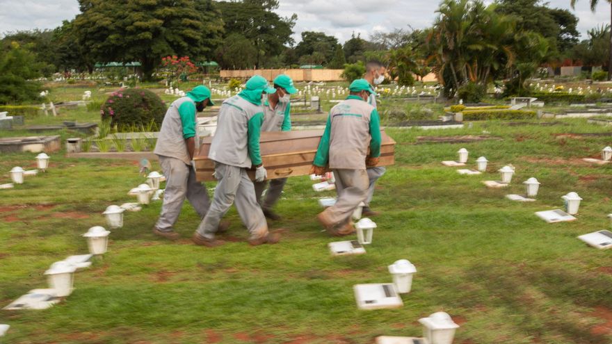 Trabajadores cargan el féretro para enterrar a una víctima de covid-19, en el cementerio Campo da Esperança, en la ciudad de Brasilia (Brasil). EFE/Joédson Alves/Archivo