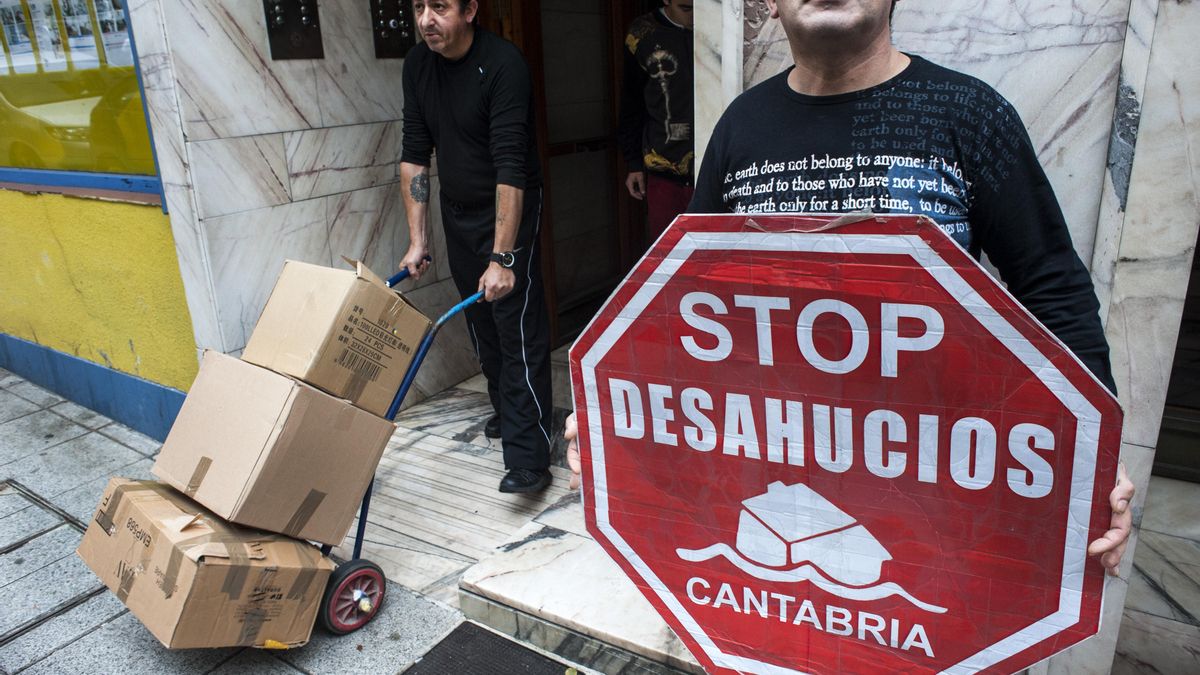 Luis, en el portal de su vivienda, sacando en cajas las pertenencias de la familia. |