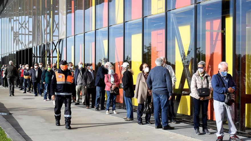 Varias personas hacen cola para recibir su vacuna durante otra jornada de vacunación masiva por el Covid-19 en el Palacio de Congresos de León este jueves. EFE/J.Casares