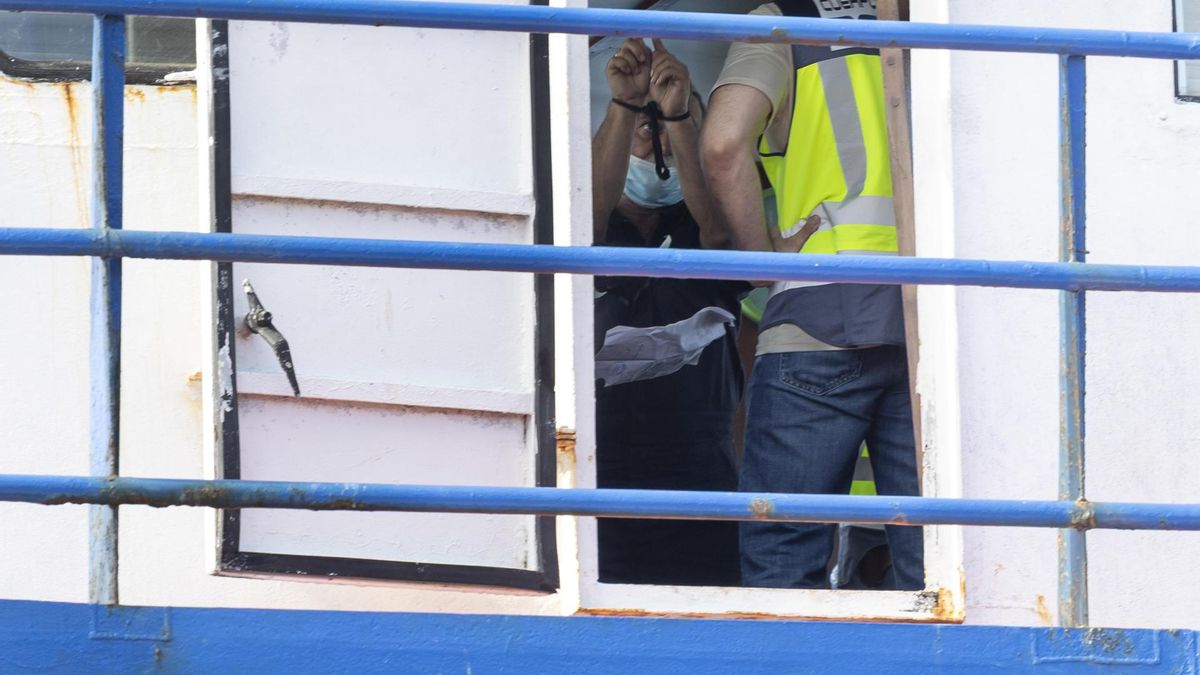 Uno de los detenidos, con un agente de la Policía Nacional, a bordo de la embarcación interceptada.