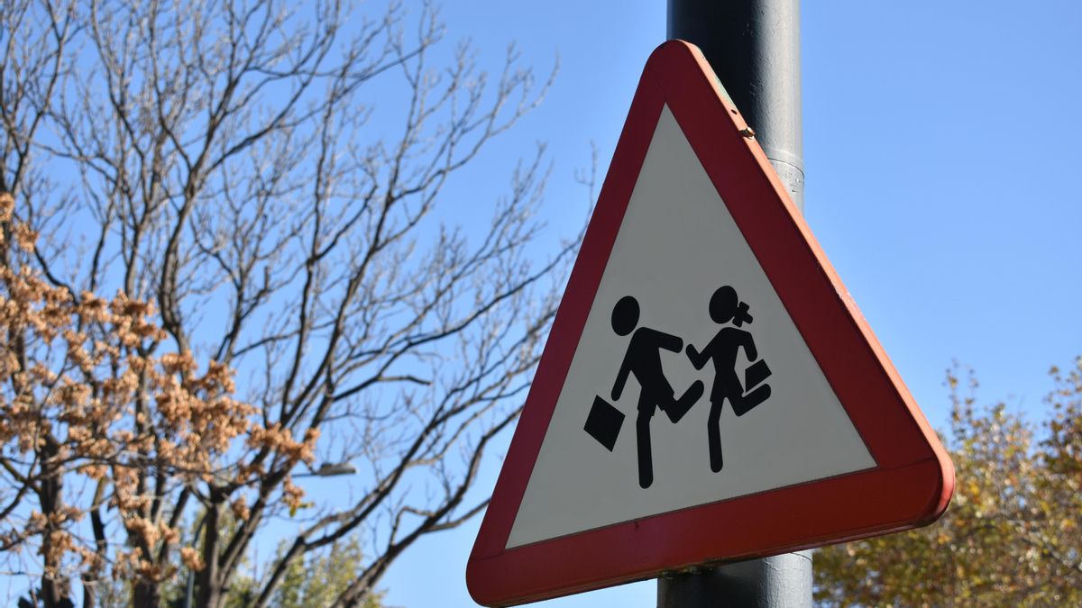 Señal de tráfico de precaución por proximidad a un colegio