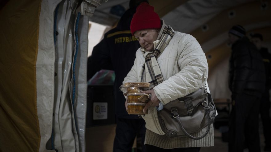 Oksana, quien no tiene calefacción en casa, sale de una de las casetas de emergencia con varios tuppers de comida caliente