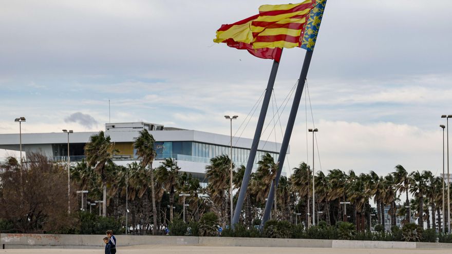 En la imagen dos personas camina por la playa de Las Arenas de Valéncia.