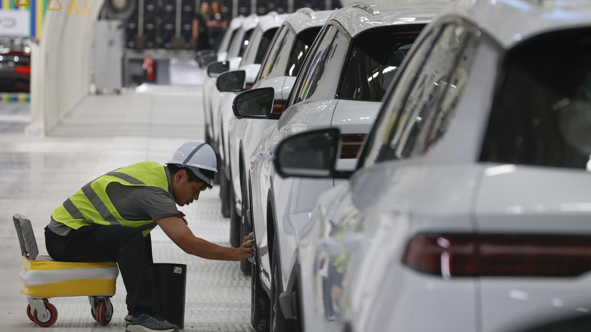 Una persona limpia un vehículo durante la inauguración de la fábrica de la empresa china Build Your Dreams (BYD), que será la base de la futura expansión en el mercado de vehículos eléctricos de América Latina este jueves, en Camaçari (Brasil). EFE/ Américo Roberto