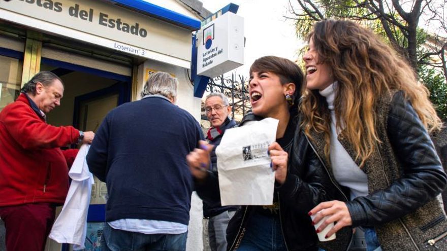 Un grupo de personas celebran en San Lorenzo de El Escorial el segundo premio del Sorteo Extraordinario de la Lotería de Navidad que ha correspondido al número 10.989, dotado con 1.250.000 euros a la serie, por lo que el poseedor de cada décimo ganará 125.000 euros.