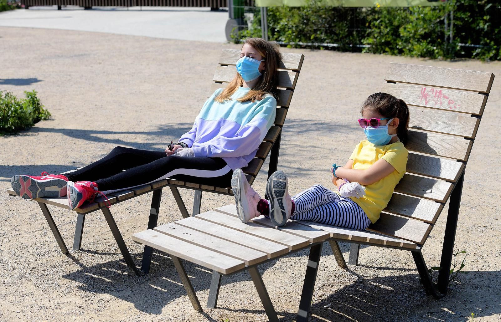 Dos niñas toman el sol en la plaza de las Glòries