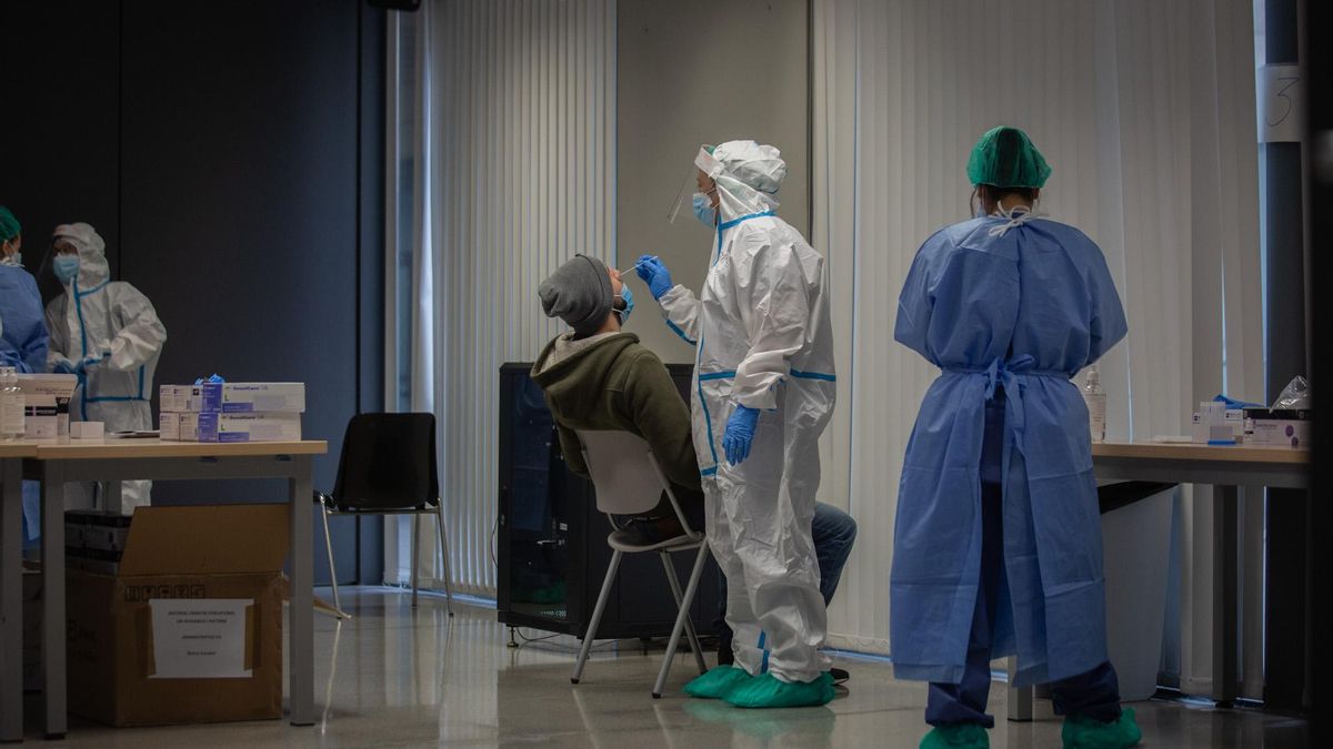 Un hombre recibe una prueba PCR en un dispositivo de cribado.