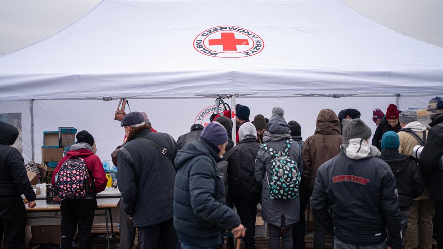 Varias personas provenientes de diferentes puntos de Ucrania, reciben comida y mantas por parte de la Cruz Roja, en las inmediaciones de la estación de tren de Lviv.