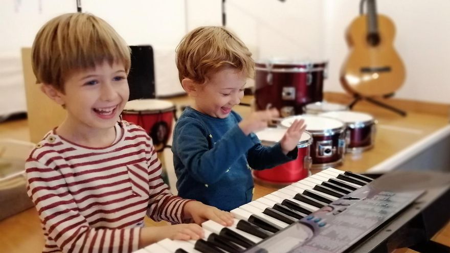 Dos alumnos del Taller Musical tocan el teclado.