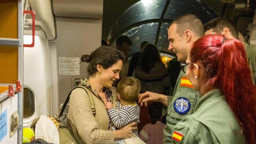 Una mujer y su bebé a la llegada a Madrid de los pasajeros evacuados desde Omán.