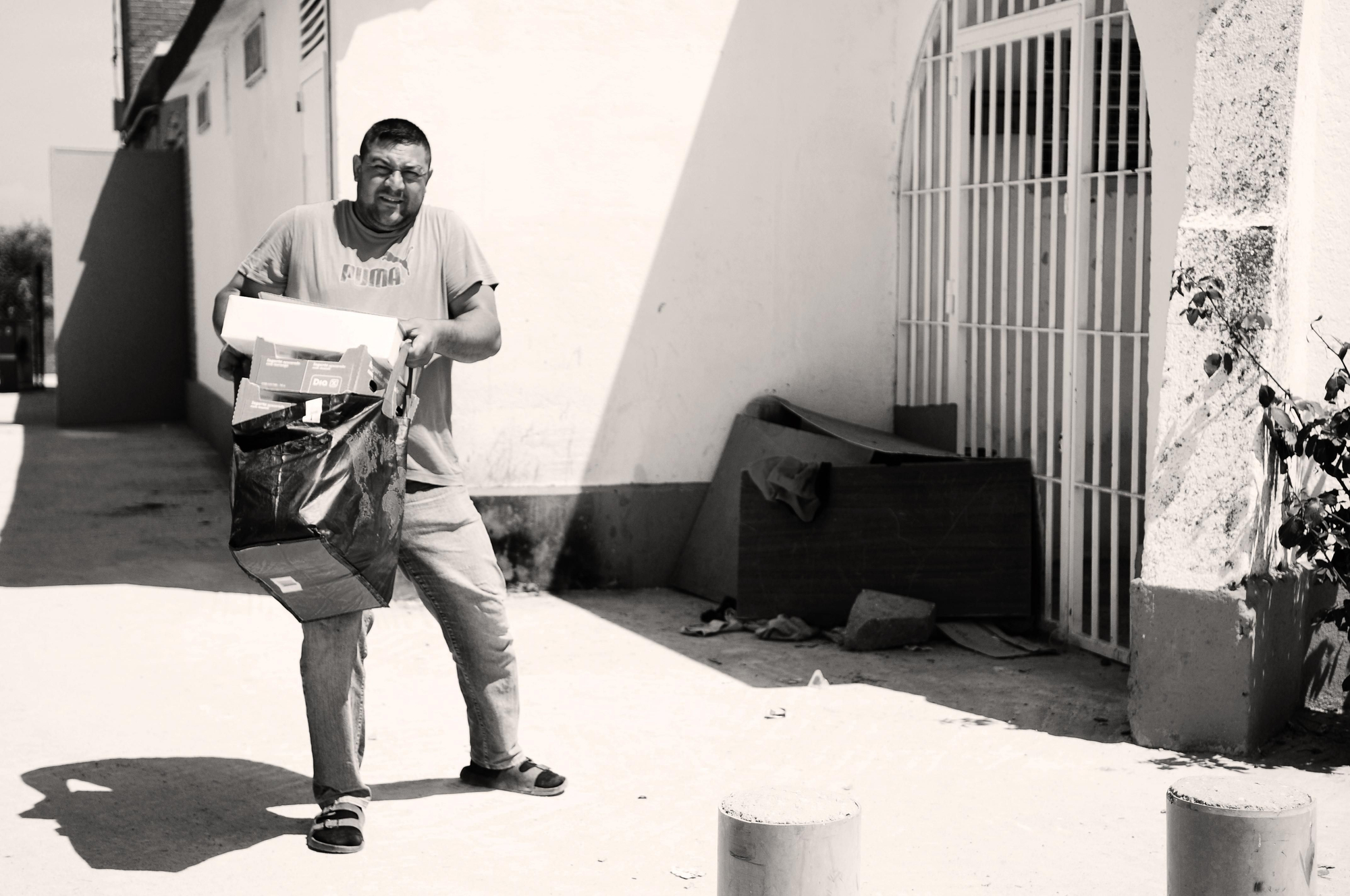 Un ciudadano del asentamiento del Gallinero recoge su bolsa de comida del banco de alimentos en la parroquia