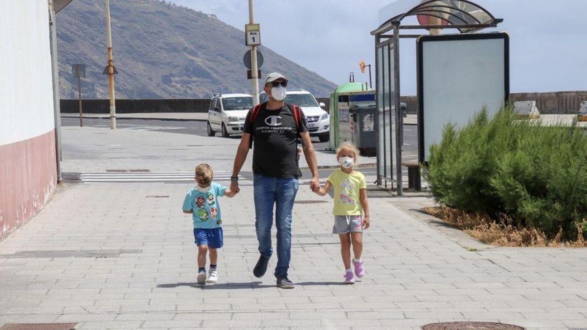 Un padre y sus hijos con mascarilla en la Avenida Marítima de Santa Cruz de La Palma