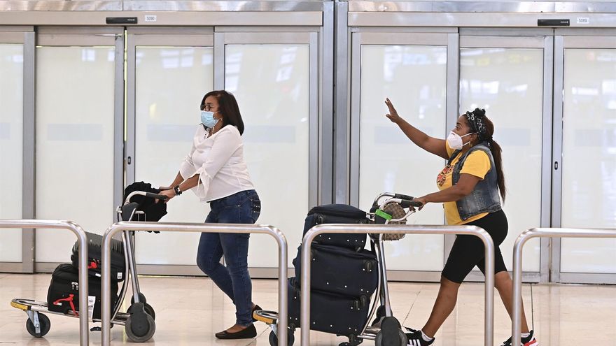 Dos turistas caminan por la T4 de Barajas este lunes, cuando España ha autorizado la entrada de viajeros con la pauta completa de la vacuna contra la COVID-19